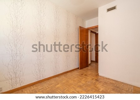 Empty room with oak parquet floor, wallpaper decorated wall with painted branches