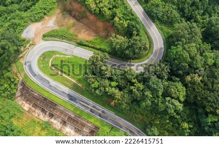 Aerial view drone fly over countryside road passing through the green forest and mountain in Thailand. Mountain winding zig zag road. Top aerial view Royalty-Free Stock Photo #2226415751