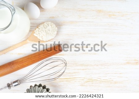 Baking cooking Ingredients background with copy space. Flour, eggs, milk, bakeware on white wooden surface. Top view, flat lay. Mockup menu, banner, header for site, baking concept