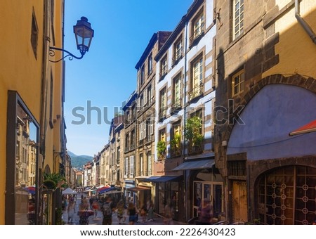 Streets of Clermont-Farrand in afternoon. Shops and residentioal buildings along walkway.