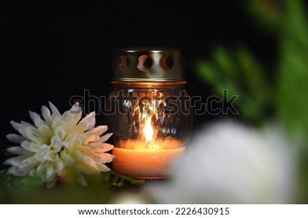 Sympathy card with candle and white chrysanthemum on dark background