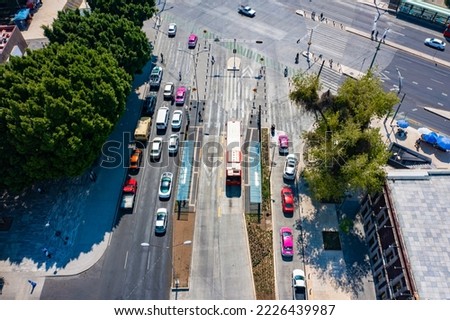 aerial footage of a busy avenue in mexico city where the crowded Metrobus public transport transits surrounded by vegetation and apartment buildings