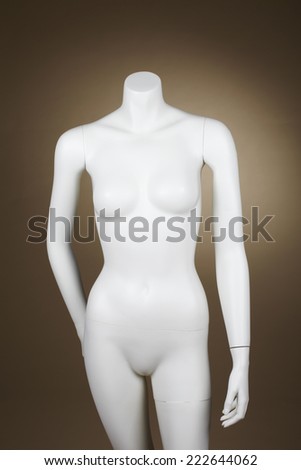 Incomplete female mannequin against brown background