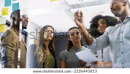 Discussing new ways to increase productivity. Cropped shot of a diverse group of businesspeople brainstorming on a glass wall in a modern office. Royalty-Free Stock Photo #2226445813