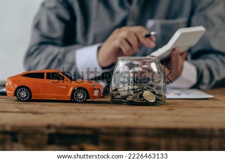 Toy car and coins on table, saving money concept to spend car expenses and growing business