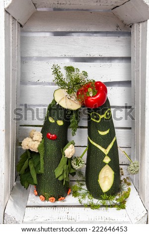 A funny pair of vegetables in love in white wooden box.