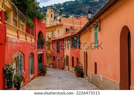 Traditional old terracotta houses on a narrow street in the Old Town of Villefranche sur Mer on the French Riviera, South of France Royalty-Free Stock Photo #2226473515