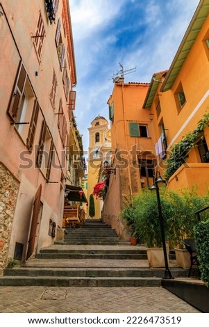 Traditional old terracotta houses on a narrow street in the Old Town of Villefranche sur Mer on the French Riviera, South of France Royalty-Free Stock Photo #2226473519