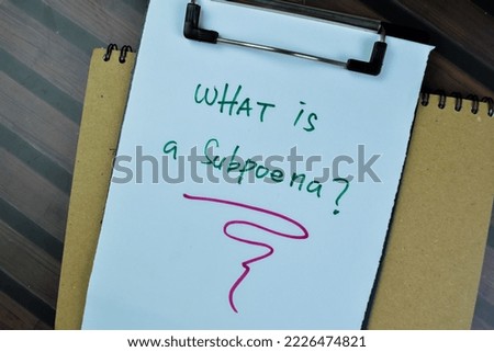Concept of What is A subpoena write on paperwork isolated on Wooden Table.
