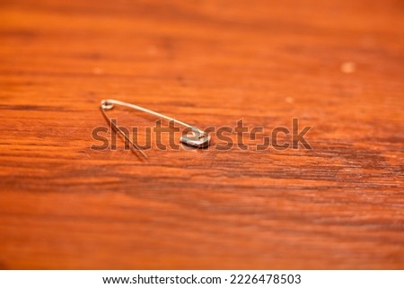 Silver safety pin on table top view