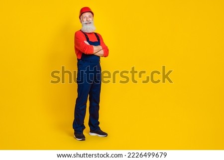 Full size photo of positive cheerful retired man builder with long beard red headgear hands crossed isolated on yellow color background Royalty-Free Stock Photo #2226499679