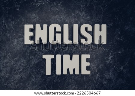 The inscription "English time" in white letters on a black marble background.