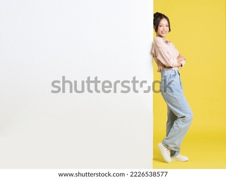 image of Asian girl standing and posing with billboard Royalty-Free Stock Photo #2226538577