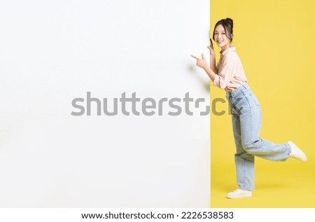 image of Asian girl standing and posing with billboard