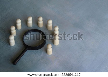 Wooden dolls and magnifying glass. Brainstorm, meeting, investigate, looking for solution concept Royalty-Free Stock Photo #2226541317