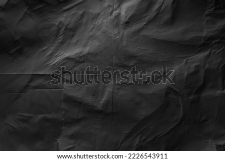 Heavy crumpled black paper texture in low light background Royalty-Free Stock Photo #2226543911