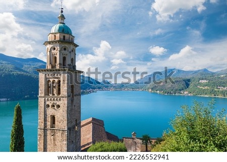 Big Swiss lake. Lake Lugano from Morcote with the bell tower of the Santa Maria del Sasso church in the foreground and the Italian town of Porto Ceresio in the background