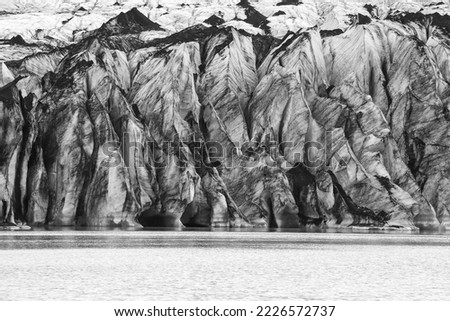 picture of a glacier and its lagoon in front. Image in black and white