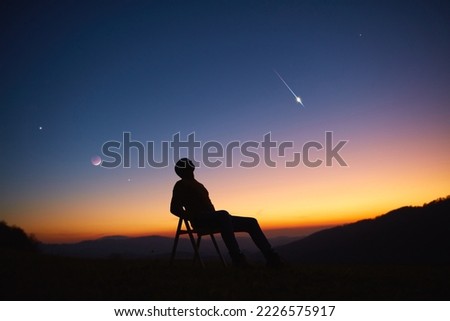 Man looking at the night sky, stars, planets, Moon and shooting stars. Royalty-Free Stock Photo #2226575917
