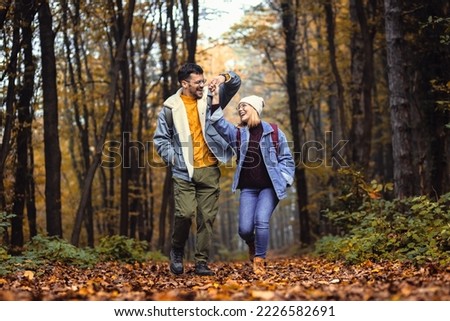 Couple spending time together walking in forest. Royalty-Free Stock Photo #2226582691