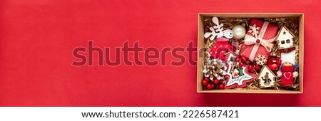 Handmade care package, seasonal gift box with christmas toys, xmas decor on red table Personalized eco friendly basket for family, friends, girl for 24 December, Christmas, New Year day Flat lay Royalty-Free Stock Photo #2226587421