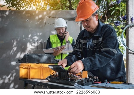 Technician are install fiber optic cable lines and Engineer are checking core assignment plan for maintenance. Royalty-Free Stock Photo #2226596083