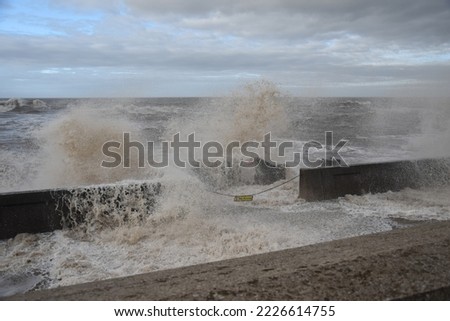 Huge waves crashing over the sea wall with a dark cloudy sky background. Taken in Blackpool England.  Royalty-Free Stock Photo #2226614755