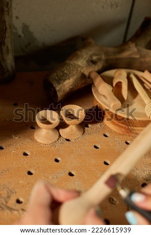 Female using power working tools graver for wooden utensils spoon, carving, grinder machine while crafting, Creating craft handmade souvenirs, woman in workshop.