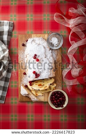Sliced Christmas stollen with raisin and cranberry on festive table top view