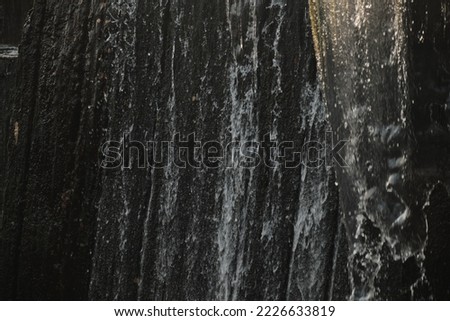 A waterfall flowing at park Wall of water A beautiful view of the falling water cascade city fountain close-up pouring Royalty-Free Stock Photo #2226633819