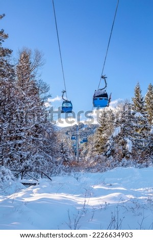 Bansko, Bulgaria winter ski resort panorama with blue gondola lift cabins, snow forest pine trees, mountain peaks view Royalty-Free Stock Photo #2226634903