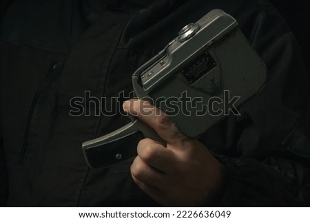 Vintage movie camera in man hand isolated on a blackbackground