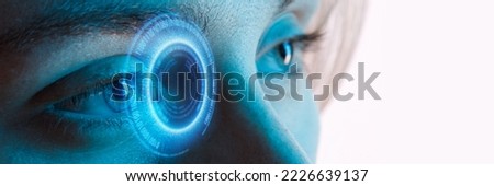 Close up view of blue eye with futuristic holographic interface to display data. Portrait of beautiful young woman, half of face. Augmented reality, future technology, internet concept. Royalty-Free Stock Photo #2226639137