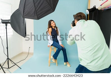 Happy hispanic woman model posing during a fashion photo shoot with a professional photographer