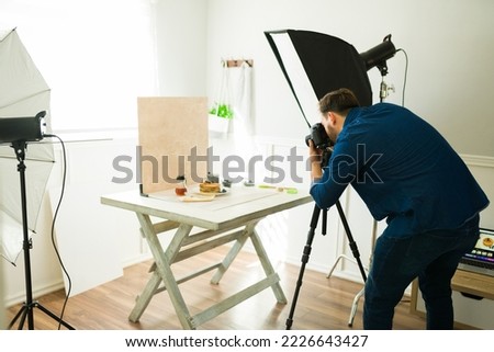 Photographer shooting food product pictures in his studio using camera equipment and a professional camera