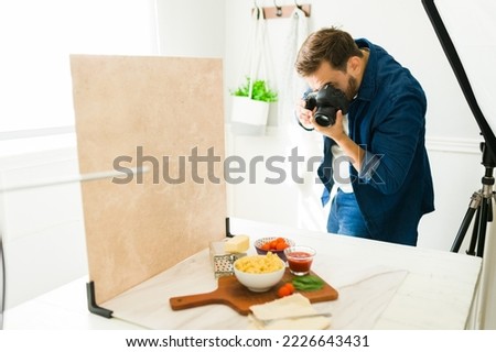 Professional food photographer using his camera during a photo shooting 