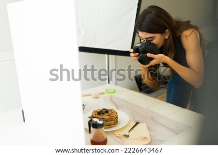 Professional photographer taking pictures with a professional camera and good lighting during shooting at her studio