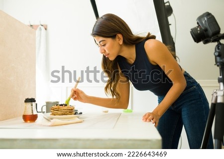 Hispanic female photographer doing beautiful food styling to take professional pictures at the photo studio