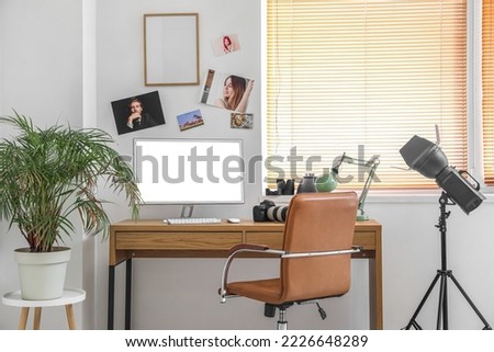 Photographer's workplace with computer and professional equipment in office