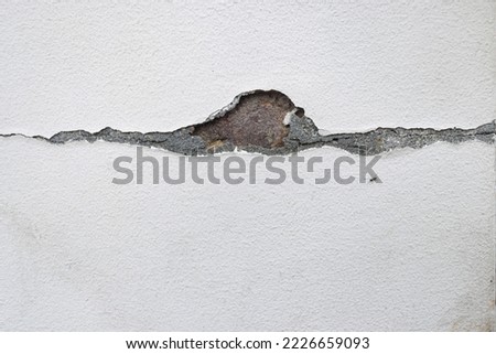 Close-up. Badly fixed building facade. Missing patch of paint in the middle; crack with flappy peeling edges. Royalty-Free Stock Photo #2226659093