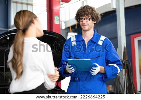mechanic talking about how to fix a car to customer in automobile repair shop