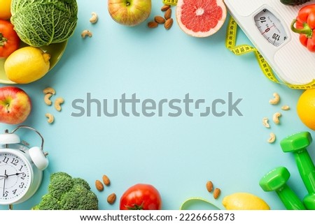 Proper nutrition concept. Top view photo of scales vegetables fruits nuts alarm clock dumbbells and tape measure on isolated pastel blue background with empty space in the middle Royalty-Free Stock Photo #2226665873