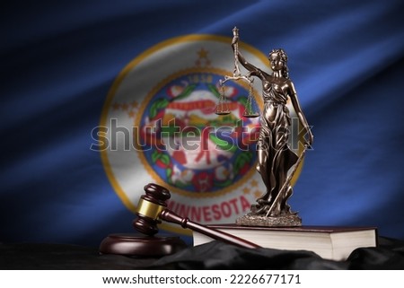 Minnesota US state flag with statue of lady justice, constitution and judge hammer on black drapery. Concept of judgement and punishment Royalty-Free Stock Photo #2226677171
