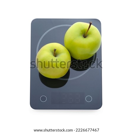 Modern kitchen scale with fresh green apples isolated on white