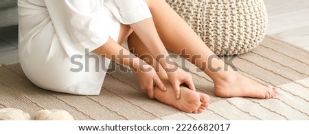 Young woman making foot massage at home Royalty-Free Stock Photo #2226682017
