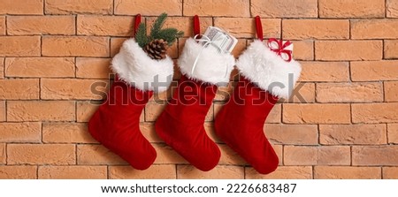 Christmas socks with gifts hanging on brick wall
