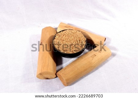 Chandan or sandalwood powder with stocks and traditional mortar, Isolated over clear colourful background. Selective focus