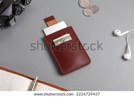 Leather cardholder with dollars and cards on the diary.