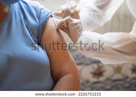 Close-up of nurse hands vaccinating patient using syringe. Doctor injecting patient upper arm. Medicine, vaccination, immunization, healthcare concept