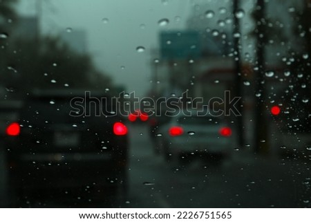 Road on rainy day, view through car window with water drops